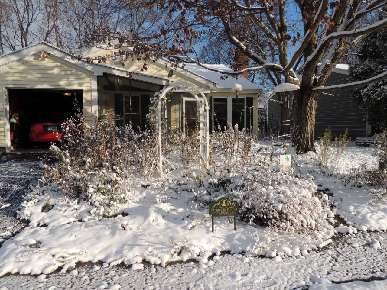 A small house with snow all over the yard.