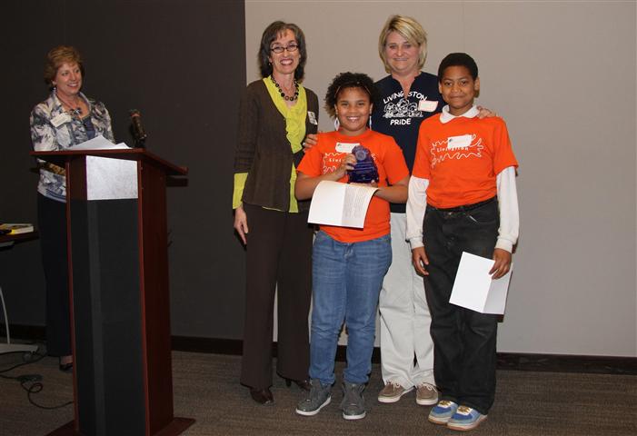 GIAC Director Christie Vargo applauds (L to R) Gerry Brevoort (CA OYBC advisor), Makaila McDowell, Teresa Stonerock (Livingston teacher), and Jaden Ward